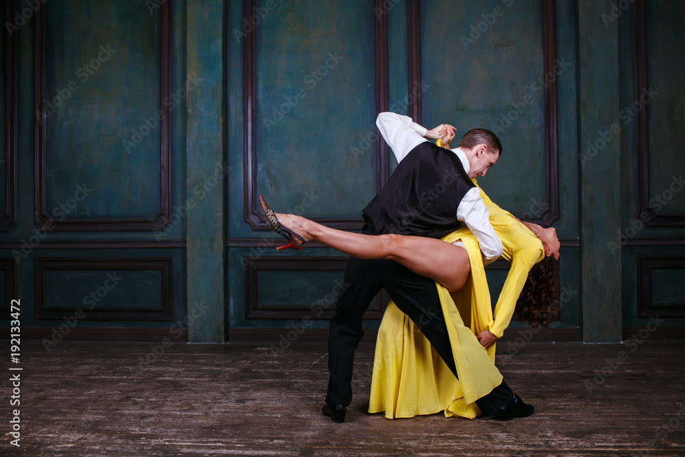 Young pretty woman in yellow dress and man dance tango - obrazy, fototapety, plakaty 