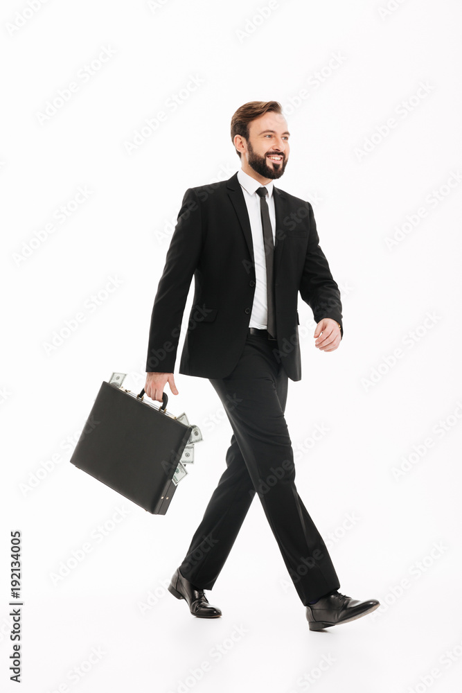 Happy young businessman with suitcase walking isolated Happy young businessman with suitcase walking isolated