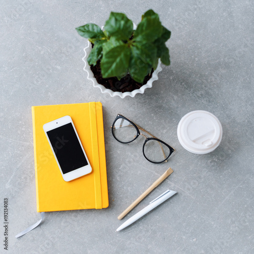 Office desk table with notebook planner  smart phone  glasses and coffee cup.