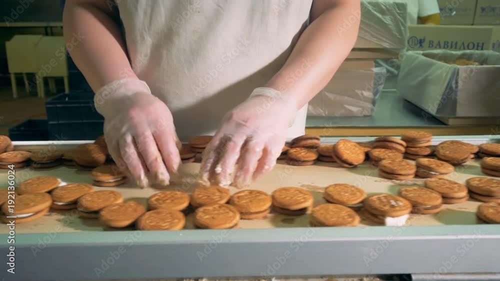 Worker at bakery production at food factory operating cookies conveyor. 4K. Worker at bakery production at food factory operating cookies conveyor. 4K.