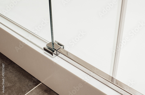 Close to lower metal fastening of the sliding glass door into the shower cabin view in the interior