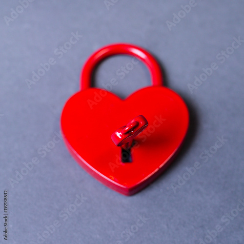 locked heartshaped padlock  with a key on grey background photo