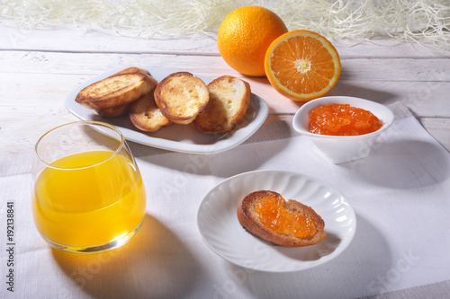 Morning Breakfast set with orange jam on bread toast and juice in glass.