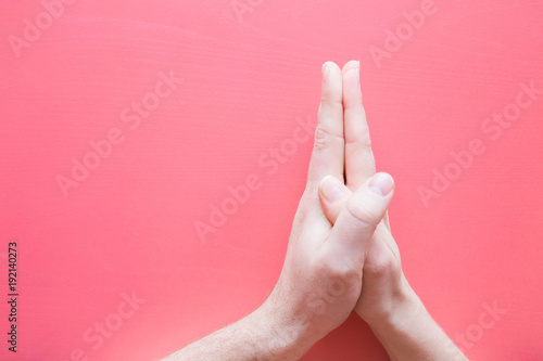 Young couple s hands bonding together on the pastel pink background. Valentine s day and relationships concept. Compatibility and peace moment. Dating service. Empty place for text.