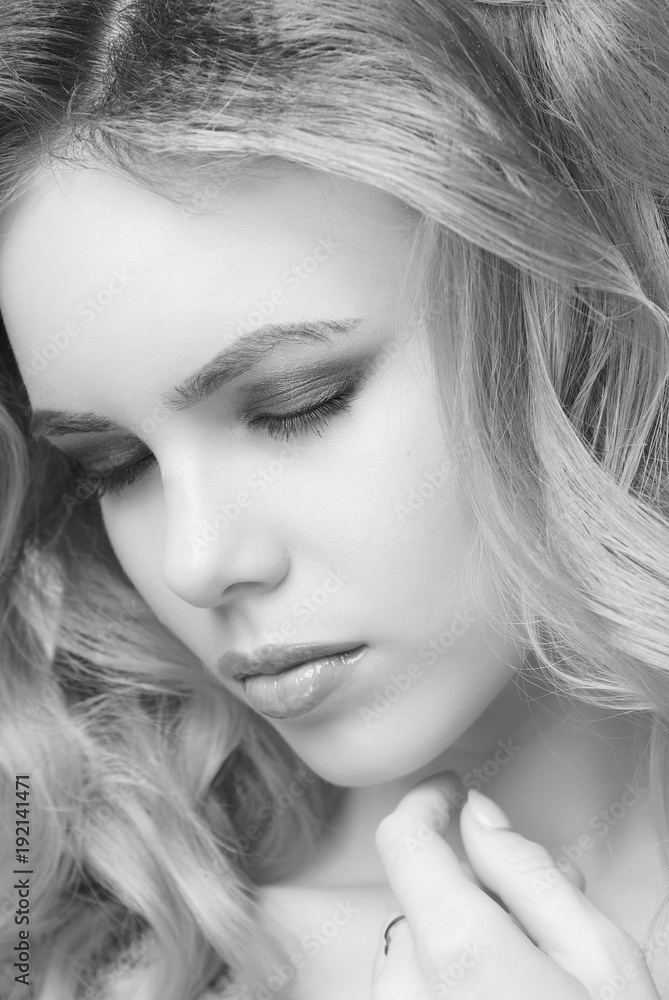 Fototapeta premium Blonde girl with Smokey ice makeup in front of closed eyes and hand under chin close-up black and white image.
