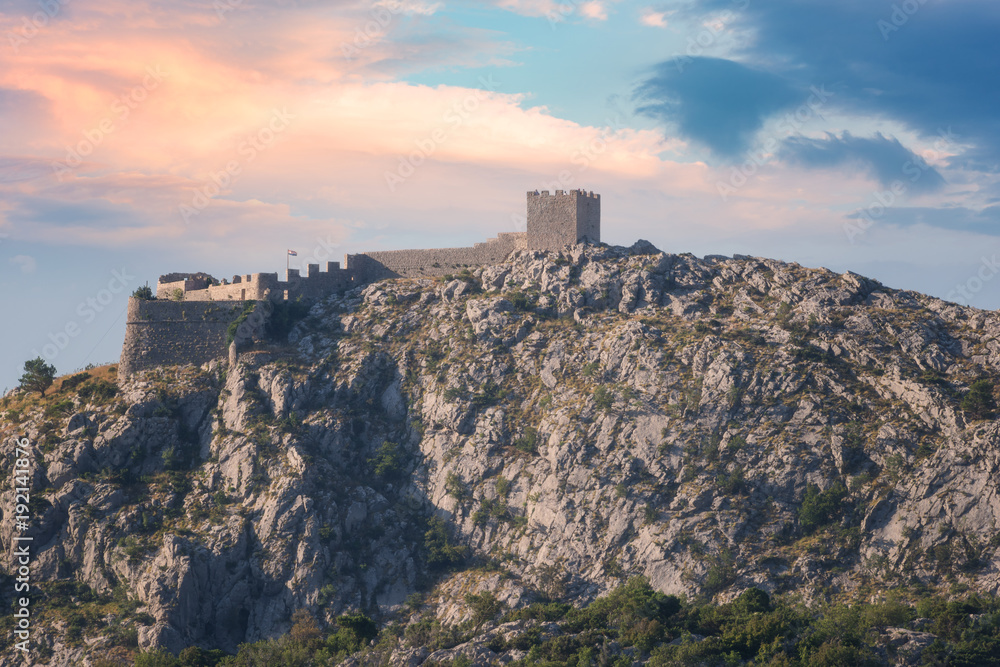 Old fortress Starigrad on the top of the rocky peak of Dinara mountains, sunset view, Omis, Croatia