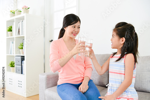mother with little girl holding water glass cup