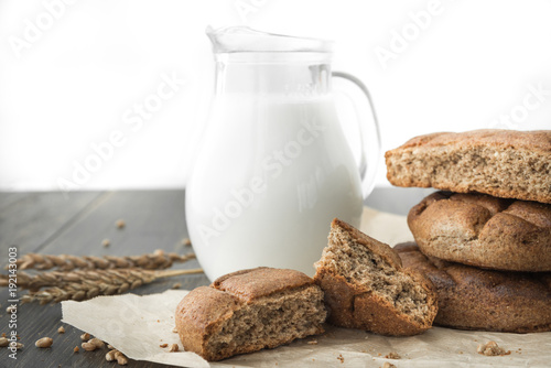 Rye flatbread with glass jug of milk on craft wrapping paper