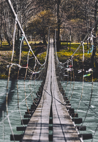 Beginning of an adventure  road into the jungle. Suspension bridge. Landscape view of Long Steel Suspension bridge above the river. balance