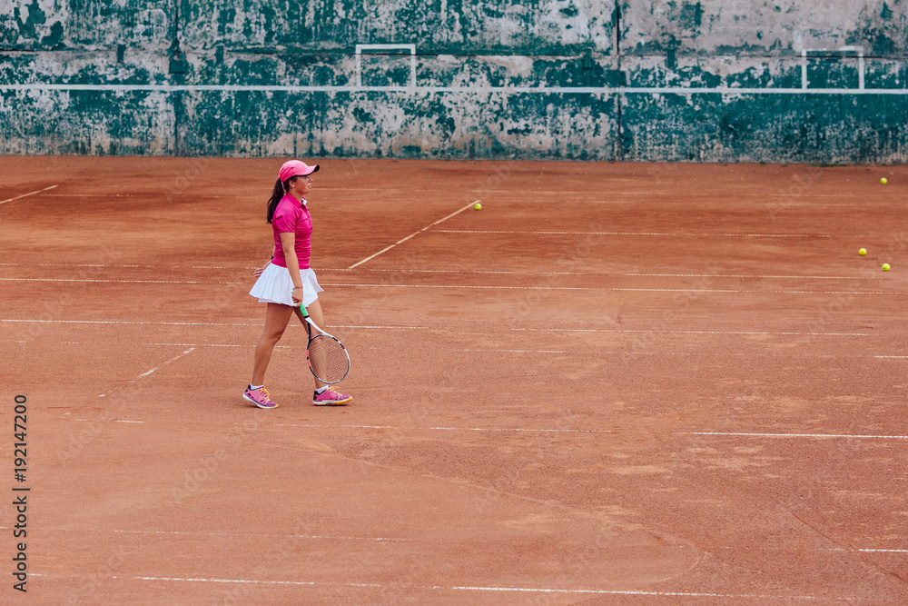 Obraz premium Tennis player. Athlete woman in white skirt and pink t-shirt playing tennis on the court. Sport concept.