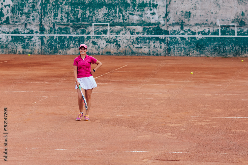 Tennis player. Cheerful beautiful woman in sportswear, standing on the court with tennis racket, looking at camera. Sport concept. Tennis player. Cheerful beautiful woman in sportswear, standing on the court with tennis racket, looking at camera. Sport concept.