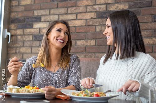 Two girlfriends having lunch together at a restaurant