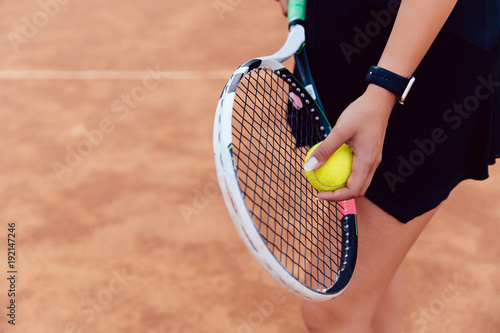 Close-up view of woman preparing to hit a tennis ball. Sport concept. © Maksym Azovtsev