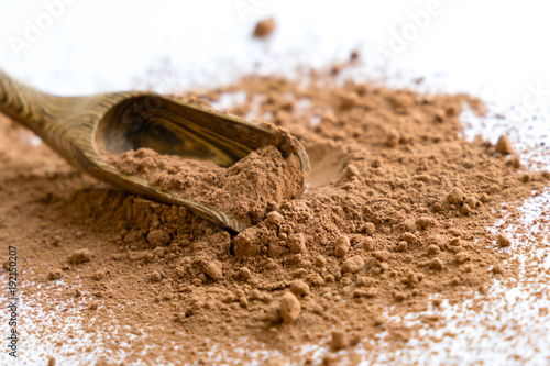 pile cocoa powder in a scoop isolated on white. heap of fresh of chocolate studio shot