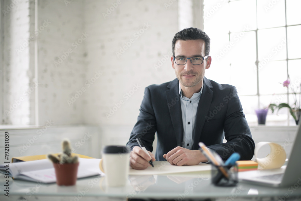 © merla - Successful businessman sitting on his office desk © merla - Successful businessman sitting on his office desk
