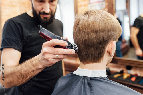 man getting trendy haircut at barber shop.