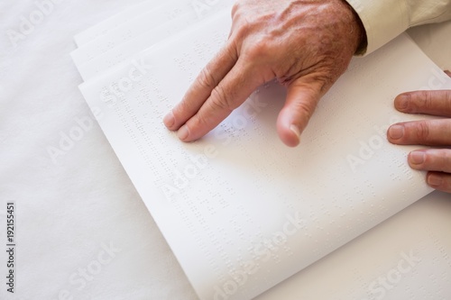 Blind senior woman using braille to read photo