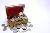 Coins in wooden treasure box 