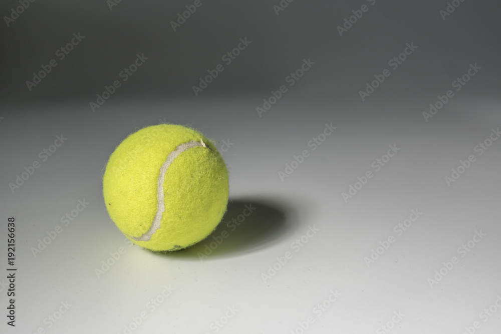 Tennis ball with shadow over grey background