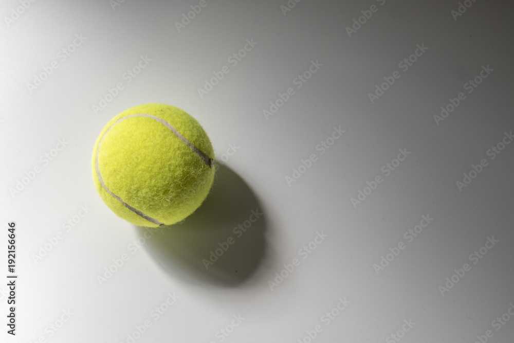 Tennis ball with shadow over grey background