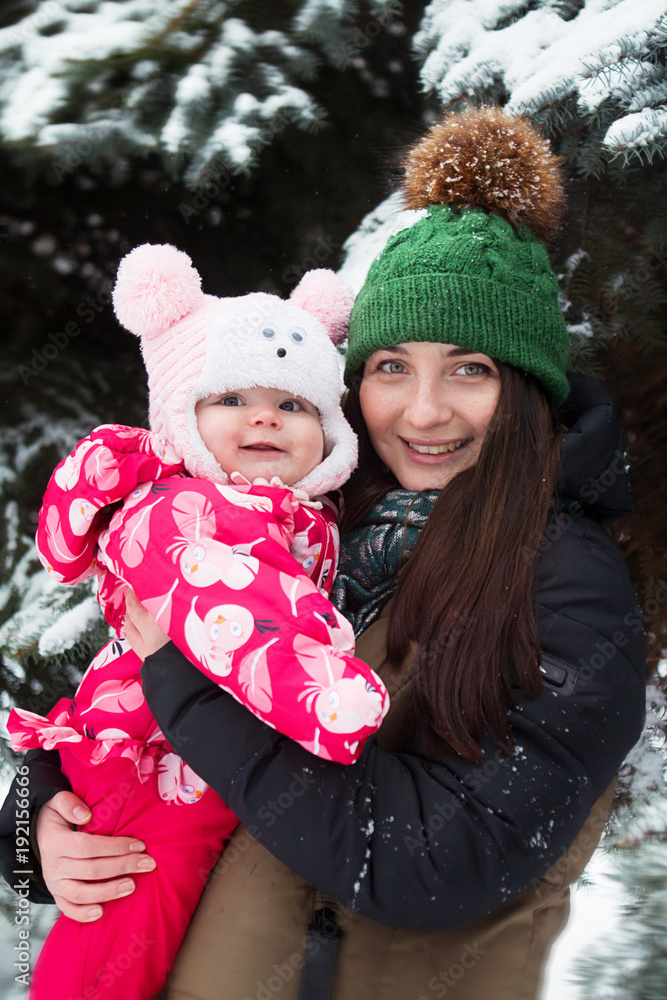 In winter, a woman with a six-month-old child. Mother with daughter In winter, a woman with a six-month-old child. Mother with daughter