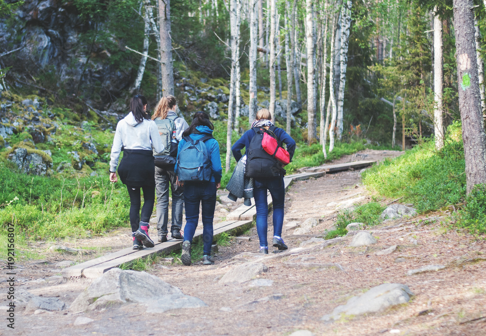Obraz premium Four girls walking on a hiking trail