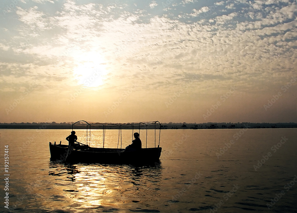 Silhouettes of people on the boat at the river Ganges in Varanasi, India at sunrise