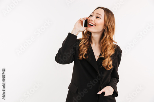 Gorgeous pleased woman having brown beautiful hair talking on mobile phone and having pleasant talk, isolated over white background