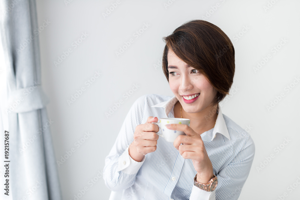 Businesswoman drinking coffee and looking out window.