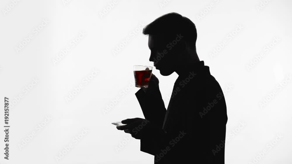 Dark silhouette of man drinking glass of tea, recreation, pH balance restore Dark silhouette of man drinking glass of tea, recreation, pH balance restore