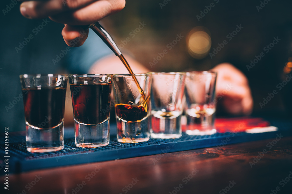 Bartender pouring and serving alcoholic drinks at bar
