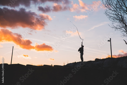 Young boy play with whip in beautiful sunset evening light