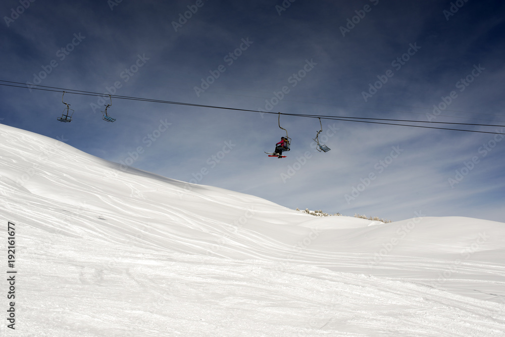 A view of a ski piste and cable car and people ski in the alps switzerland