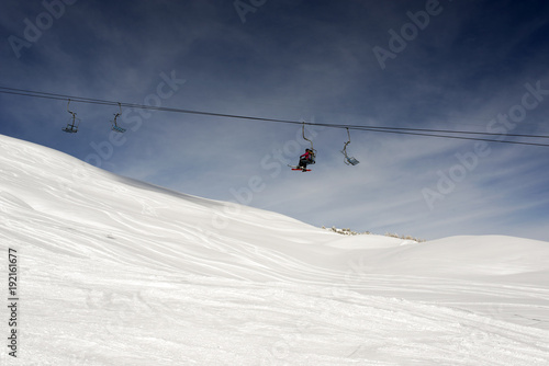 A view of a ski piste and cable car and people ski in the alps switzerland