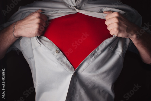 Foto Superhero Tears off his Shirt on a dark Background.
