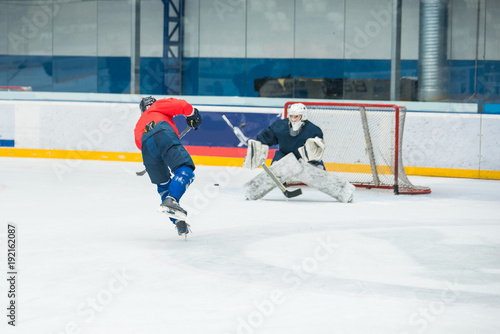 Hockey player and goalkeeper on ice, training sport photo