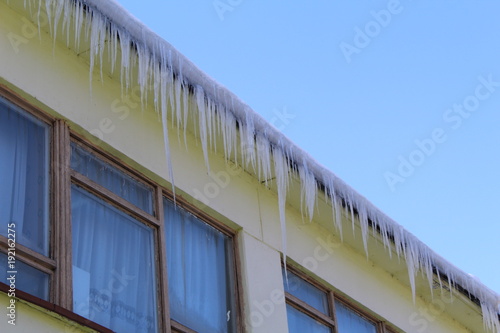 Icicles hanging from the roof of the building.
