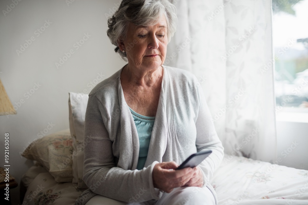 Senior woman sending a message with her smartphone Senior woman sending a message with her smartphone