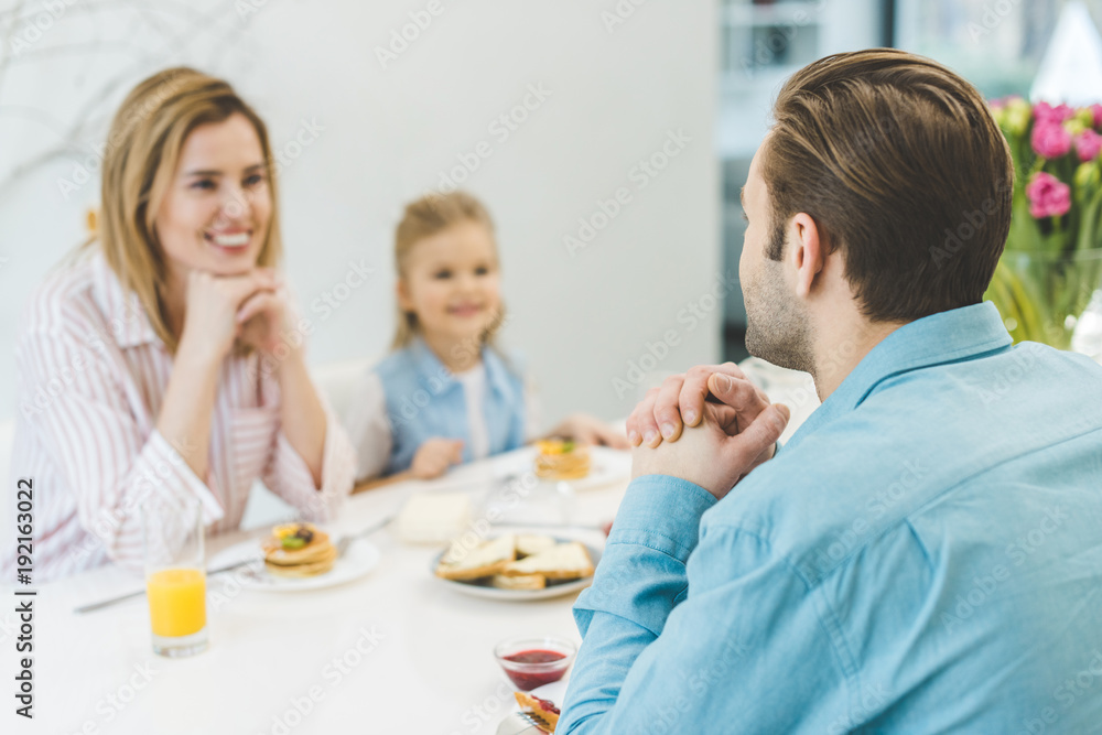 selective focus of man having breakfast together with family at home