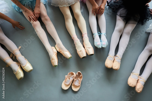 Six ballerinas on the floor, top view. Ballet pointe shoes for little ballet girl. Classical ballet school.