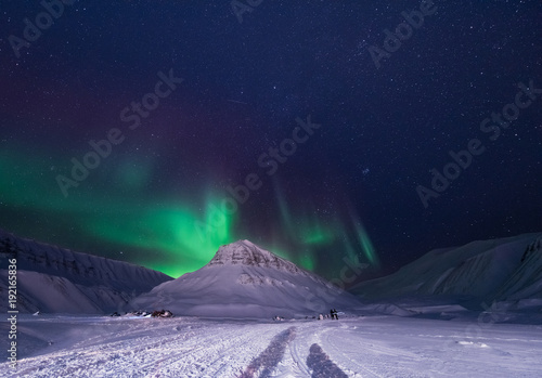 The polar arctic Northern lights aurora borealis sky star in Norway Svalbard in Longyearbyen city snowscoter mountains