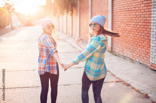 Wallpaper Mural Two good looking females are walking outdoors at sunset. Torontodigital.ca