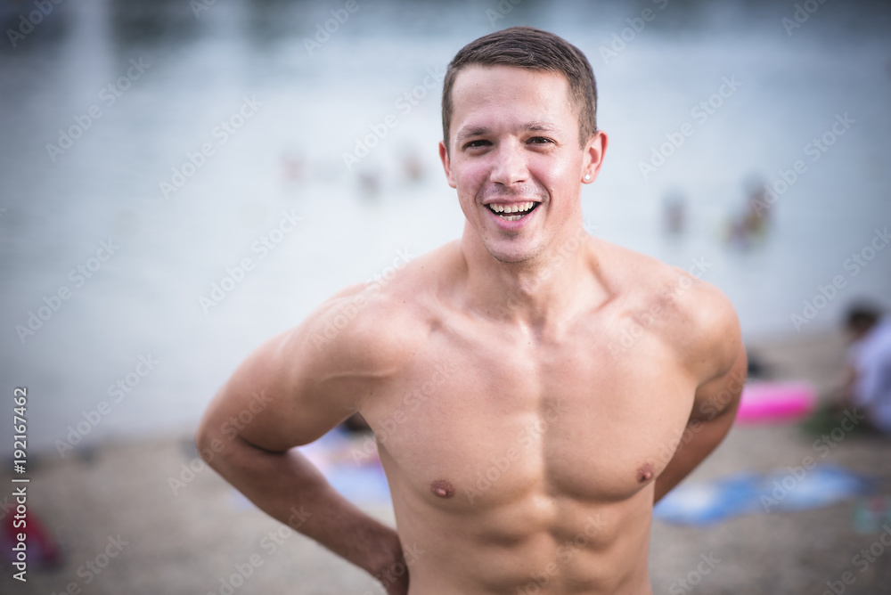 Obraz premium Young athletic caucasian man posing on the beach