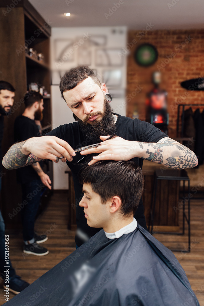 man getting trendy haircut at barber shop.