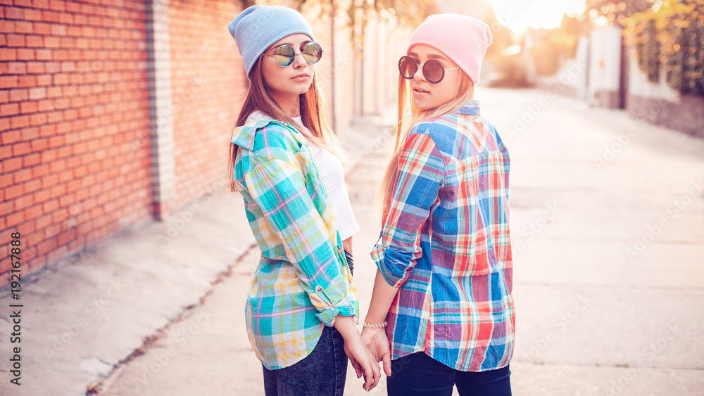 Lovely Females are looking back on the street at suset.