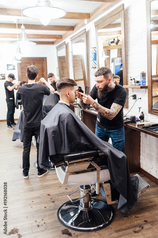 man getting trendy haircut at barber shop. man getting trendy haircut at barber shop.