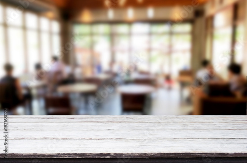 Selected focus empty brown wooden table and Coffee shop or restaurant blur background with bokeh image. for your photomontage or product display. © snowing12
