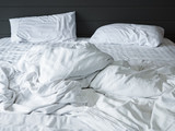 messy white bedding sheets and pillow in bedroom background ,Unmade messy bed after comfort sleep concept