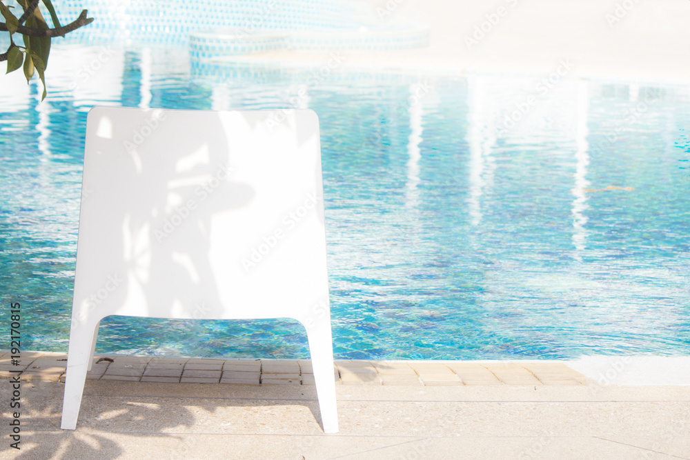 Fototapeta premium White chair next to the pool.