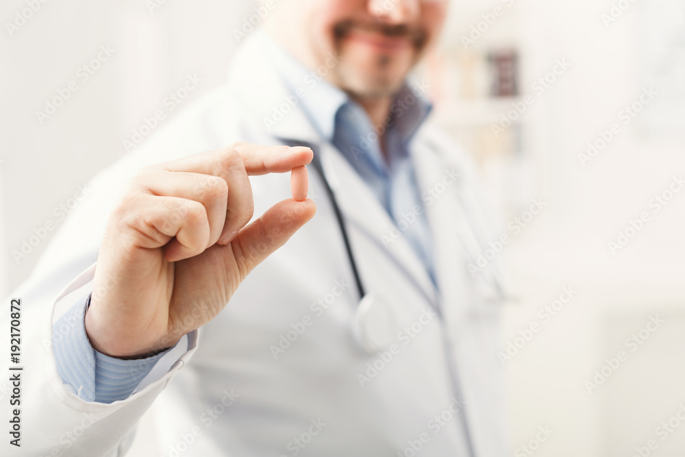 Pill in doctor's hands closeup